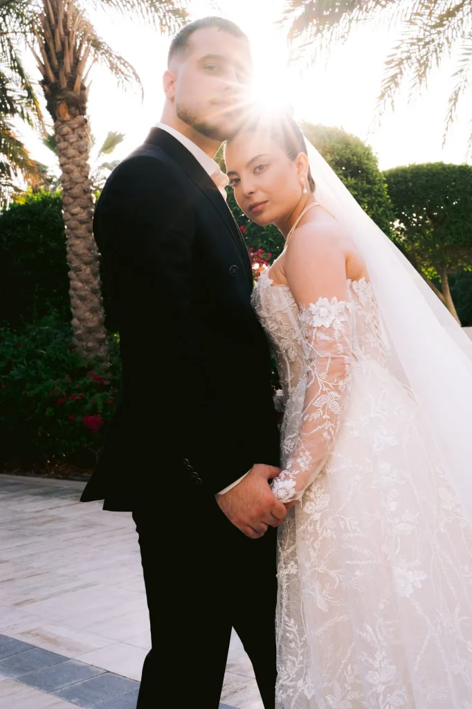 Bride and groom at sunset under palm trees