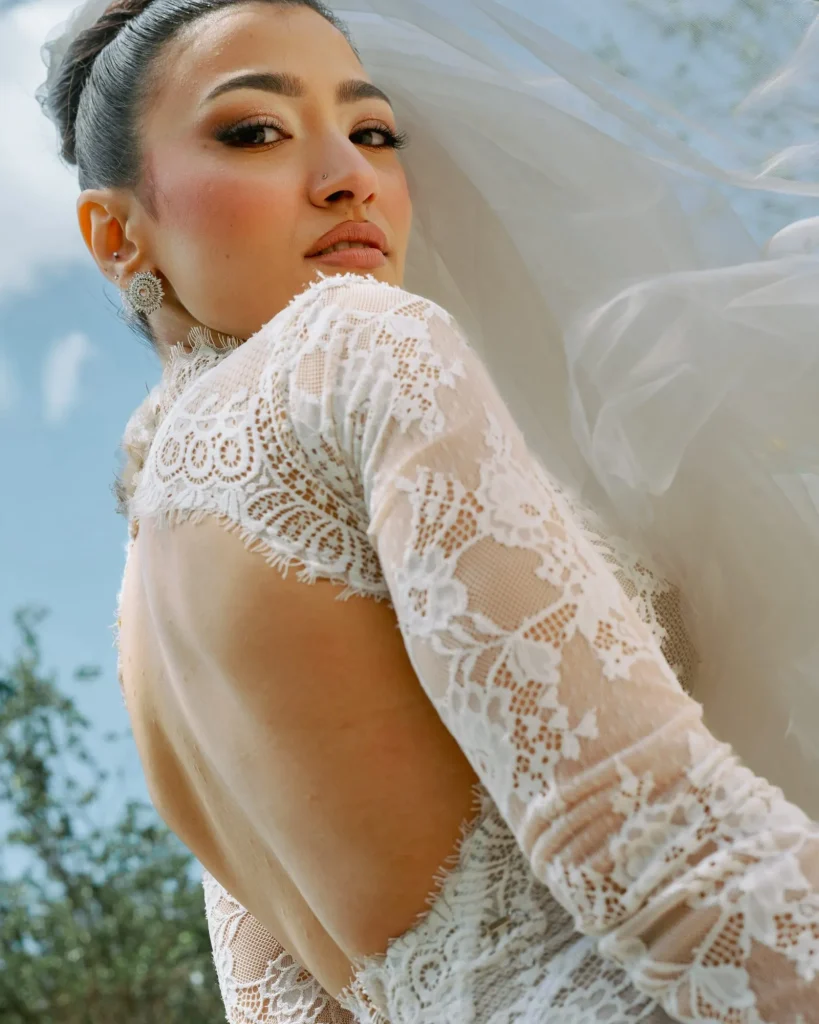 Bride in a lace backless gown looking over her shoulder
